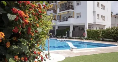 a swimming pool in front of a building at Sitges Oasis in Sitges