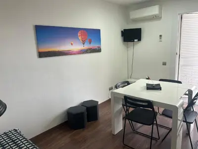 a room with a white table and chairs and a picture of balloons at Mery Castelldefels Beach in Castelldefels