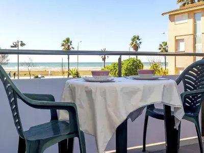 a table on a balcony with a view of the beach at Mery Castelldefels Beach in Castelldefels