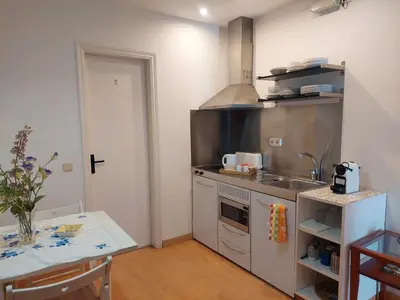 a small kitchen with a sink and a table at Apartaments Mare Nostrum in Sitges