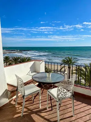 a patio with a table and chairs and the ocean at Apartaments Mare Nostrum in Sitges