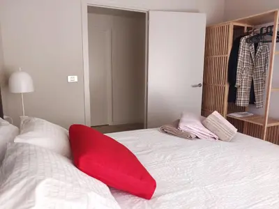 a red pillow sitting on top of a bed at Exclusive Beach District Flat - Fully Renovated in Barcelona