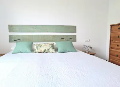 a bedroom with a white bed with two pillows at Cozy apartment next to the beach in Sitges