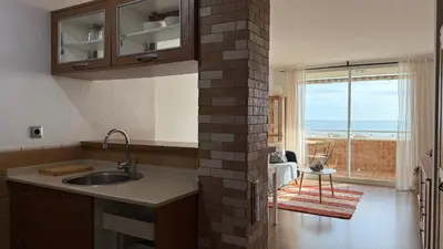 a kitchen with a sink and a view of the ocean at Apartamento precioso en primera línea de mar in Les Botigues de Sitges