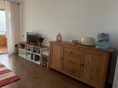 a room with a wooden dresser with a tv on it at Apartamento precioso en primera línea de mar in Les Botigues de Sitges