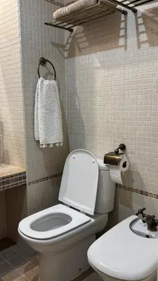 a bathroom with a white toilet and a sink at Apartamento precioso en primera línea de mar in Les Botigues de Sitges