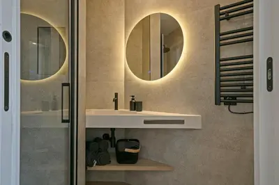 a bathroom with a sink and two mirrors on the wall at 3 Bedroom Cozy Apartment In Joan Austria in Barcelona