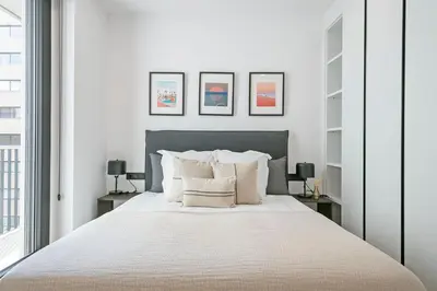 a white bedroom with a large bed with white pillows at 3 Bedroom Cozy Apartment In Joan Austria in Barcelona