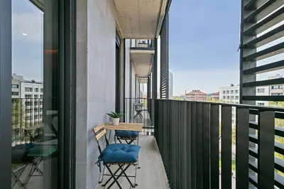 a balcony with two chairs and a table on it at 3 Bedroom Cozy Apartment In Joan Austria in Barcelona