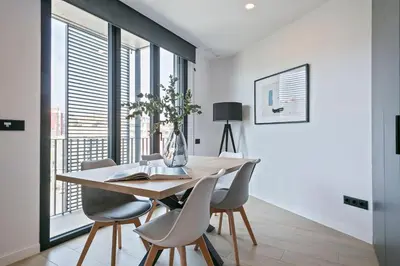 a dining room with a wooden table and chairs at 3 Bedroom Cozy Apartment In Joan Austria in Barcelona