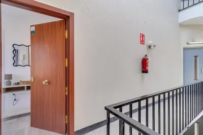 a fire extinguisher on a wall next to a door at Guest Ready‑Bright & Stylish Flat with 3 Terraces in Barcelona