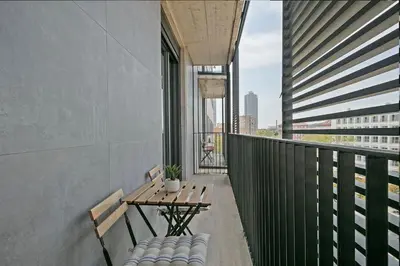 a balcony with a table and chairs on a building at 1 Bedroom Cozy Aparment Joan Austria in Barcelona