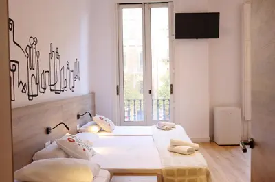 a bedroom with a bed and a desk and a bed at lullaby by hamilton in Barcelona