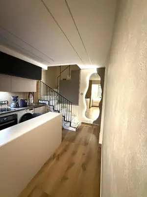 a kitchen with a staircase leading to a living room at Beautiful duplex apartment in center Barcelona in Barcelona
