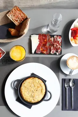 a table with plates of food on a table at Upper Diagonal in Barcelona