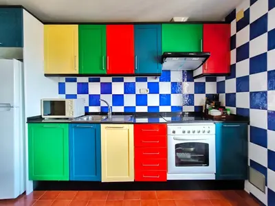 a kitchen with colorful cabinets and a stove at Apartamento Canet de Mar Playa, Costa de Barcelona in Canet de Mar