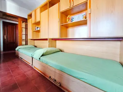 two beds in a room with wooden cabinets at Apartamento Canet de Mar Playa, Costa de Barcelona in Canet de Mar