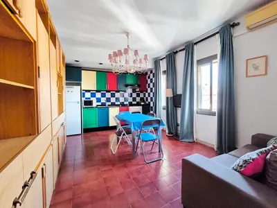 a living room with a blue table and a kitchen at Apartamento Canet de Mar Playa, Costa de Barcelona in Canet de Mar