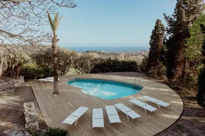 a swimming pool with white lounge chairs around it at Ca l'Andreu Ecoturisme in Tiana