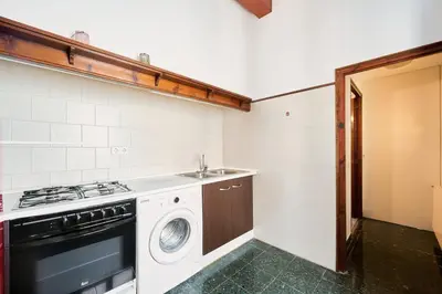a kitchen with a washing machine and a sink at Apartamento en Caldes d'Estrac in Caldes d'Estrac