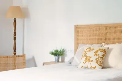 a white bed with a pillow and a lamp at Apartamento en Caldes d'Estrac in Caldes d'Estrac