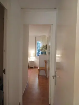 a hallway with a room with a table and a chair at Lovely little house with garden in Sant Vicenç de Montalt