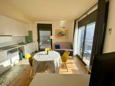 a kitchen with a table and chairs in a room at Loft muy soleado en Terrassa in Terrassa