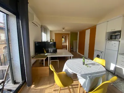 a living room with a table and yellow chairs at Loft muy soleado en Terrassa in Terrassa