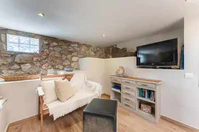 a living room with a couch and a tv on a wall at Casa Olivella #7 by Happy Houses Barcelona in Olivella