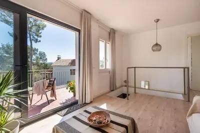 a living room with a large window and a table at Casa Olivella #7 by Happy Houses Barcelona in Olivella