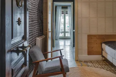 a room with a chair and a bedroom with a bed at Brummell Apartments Gracia in Barcelona