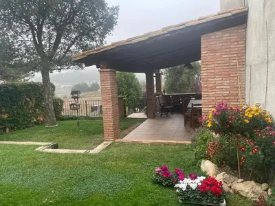 a brick pergola with flowers in a yard at Cal correu Hort - Xida in Collsuspina