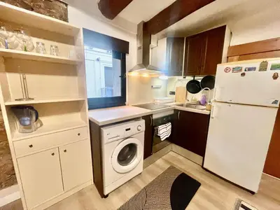 a small kitchen with a refrigerator and a washing machine at Ven una temporada al centro de Barcelona in Barcelona