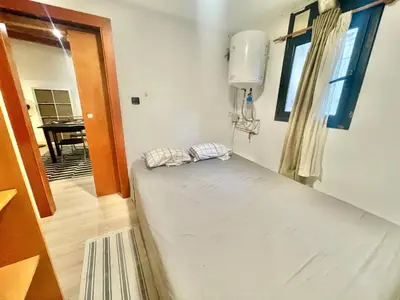 a bed in a room with a window and a table at Ven una temporada al centro de Barcelona in Barcelona