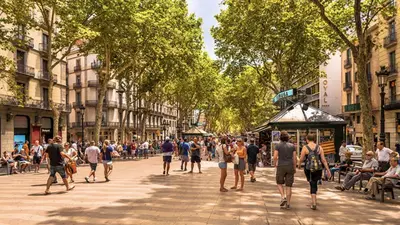 a crowd of people walking down a city street at Ven una temporada al centro de Barcelona in Barcelona