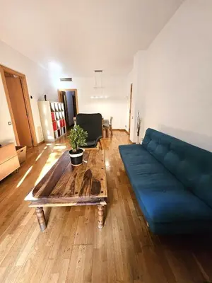a living room with a blue couch and a wooden table at Ramblas flat 3Bedroom and Pool Min 32 days in Barcelona