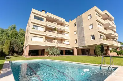 a villa with a swimming pool in front of a building at Modern Apartment Lily close to beach with Com Pool and AC in Sitges