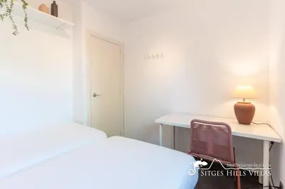a bedroom with a desk and a chair next to a window at Modern Apartment Lily close to beach with Com Pool and AC in Sitges