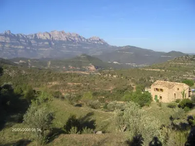 a house on a hill with mountains in the background at Music room in Montserrat in Castellbell i Vilar