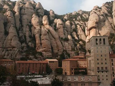 a mountain with a city and buildings in front of it at Music room in Montserrat in Castellbell i Vilar