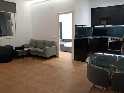a living room with a couch and a kitchen at Can Masia in Olivella