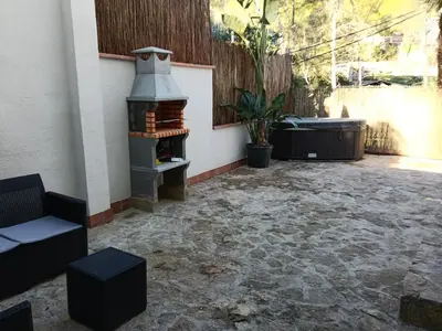 a patio with a fireplace and a tub at Can Masia in Olivella