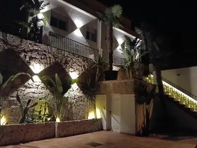 a house with plants on the wall at night at Can Masia in Olivella