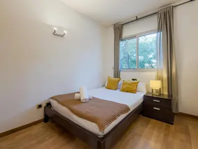 a bedroom with a bed with yellow pillows and a window at Bed BCN Vila Olímpica. in Barcelona