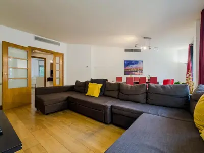 a living room with a brown couch and red chairs at Bed BCN Vila Olímpica. in Barcelona