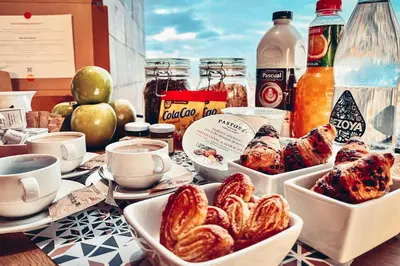 a table topped with dishes of food and drinks at Enjoybcn Coliseum Apartments in Barcelona