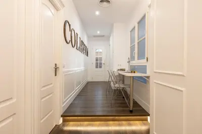 a hallway with a door and a table and chairs at Enjoybcn Coliseum Apartments in Barcelona
