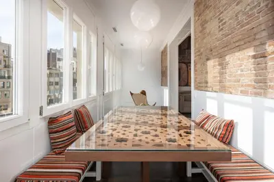 a dining room with a glass table and two chairs at Enjoybcn Coliseum Apartments in Barcelona