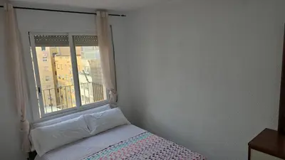 a bedroom with a window with a bed and a bedspread at A 10 de sagrada familia minutos caminando in Barcelona