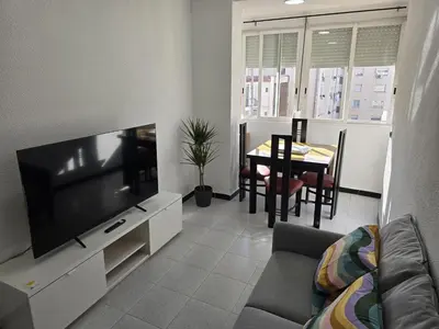 a living room with a television and a table with chairs at A 10 de sagrada familia minutos caminando in Barcelona